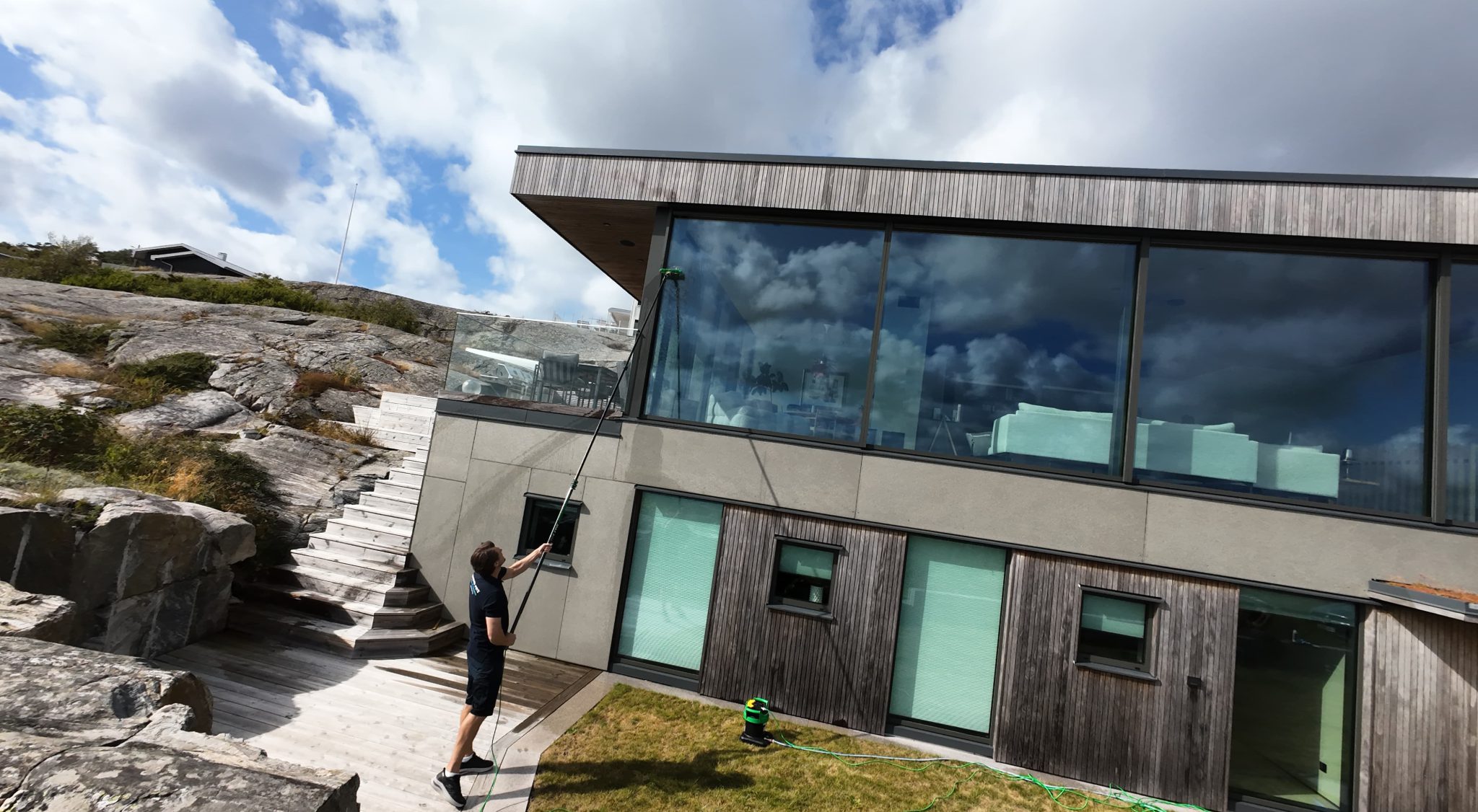 Överblick över fönsterputsning vid en villa med stora glasytor
