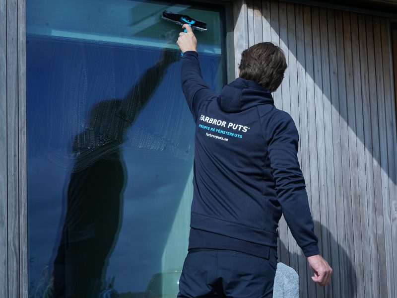 Handputsning längs överkanten på ett fönster
