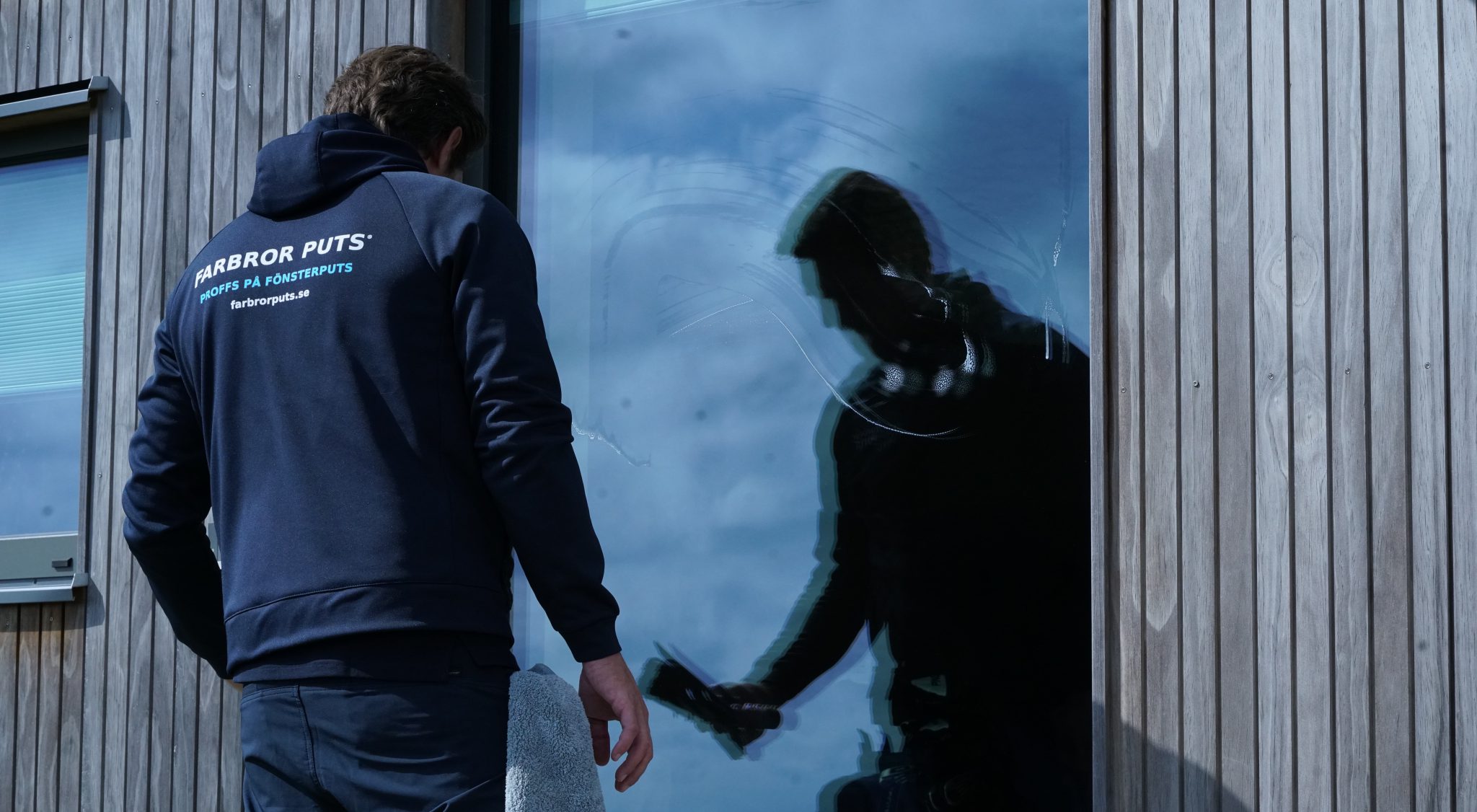 Fönsterputsare arbetar vid ett lättåtkomligt fönster i markplan