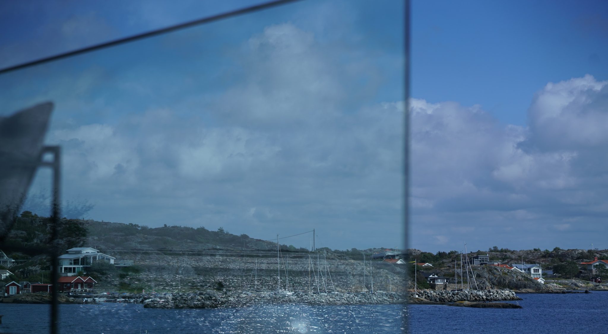 Himmel och kustmiljö speglas i ett stort glasparti