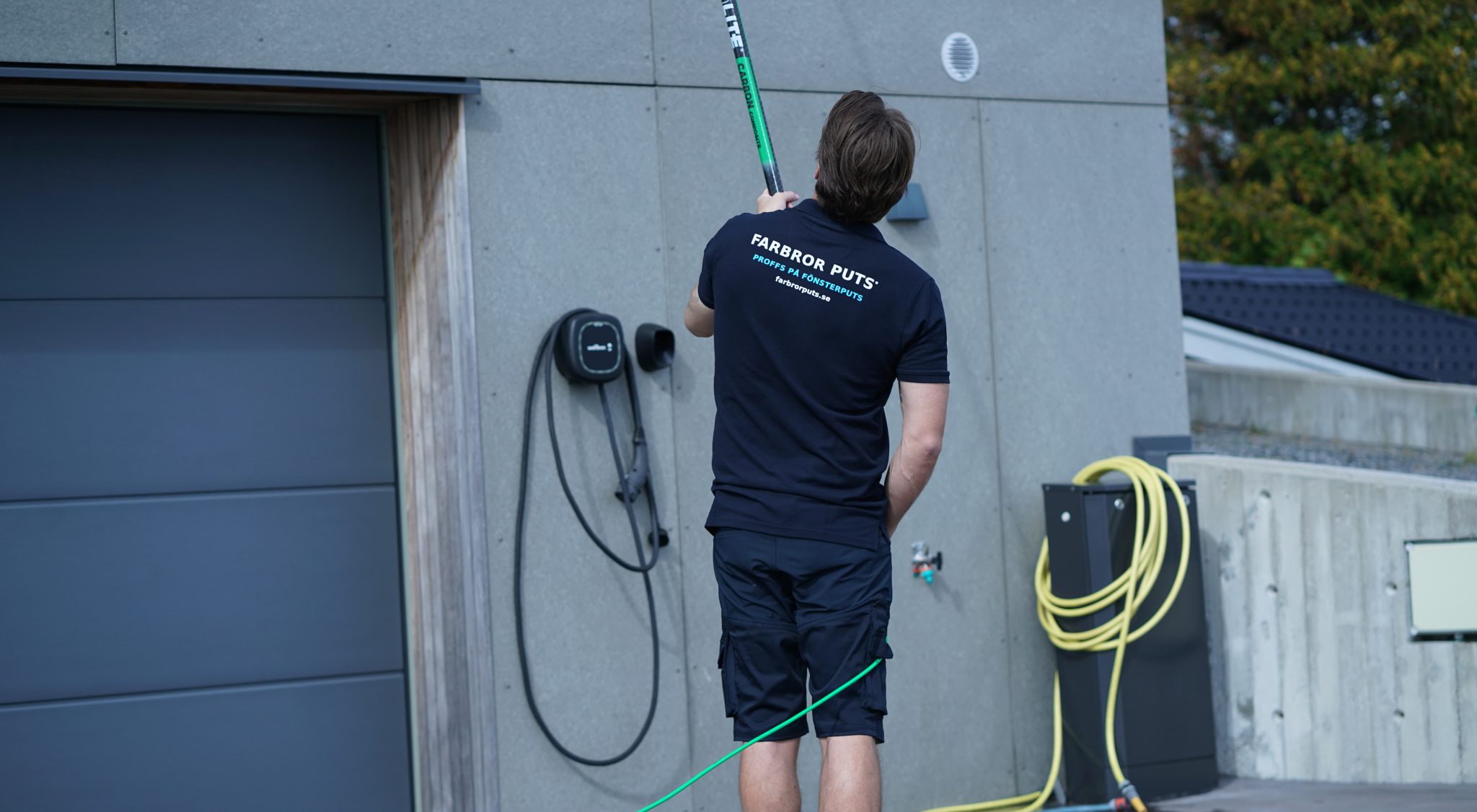 Farbror Puts arbetar med teleskopskaft vid en garageuppfart