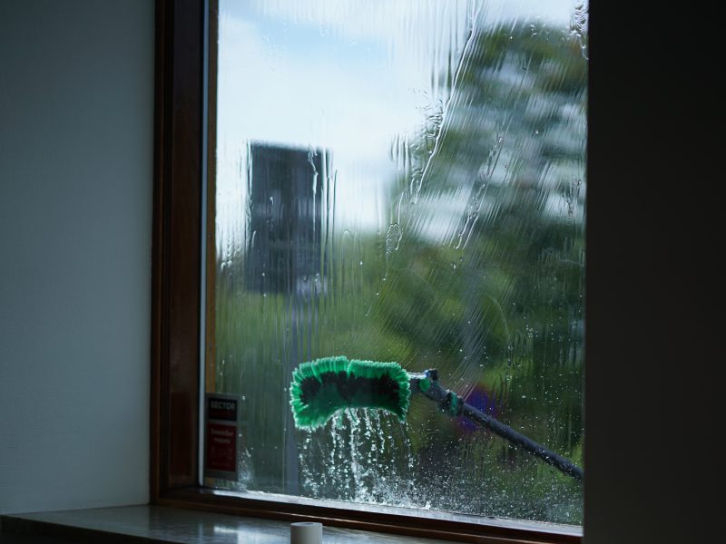 Fönsterputs med rentvattenborste sedd genom glaset