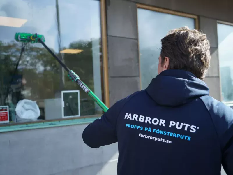 Fönsterputs med teleskopborste vid en butikslokal