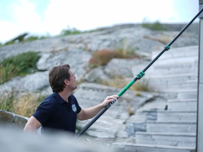 Fönsterputsare arbetar vid en villa intill klippor